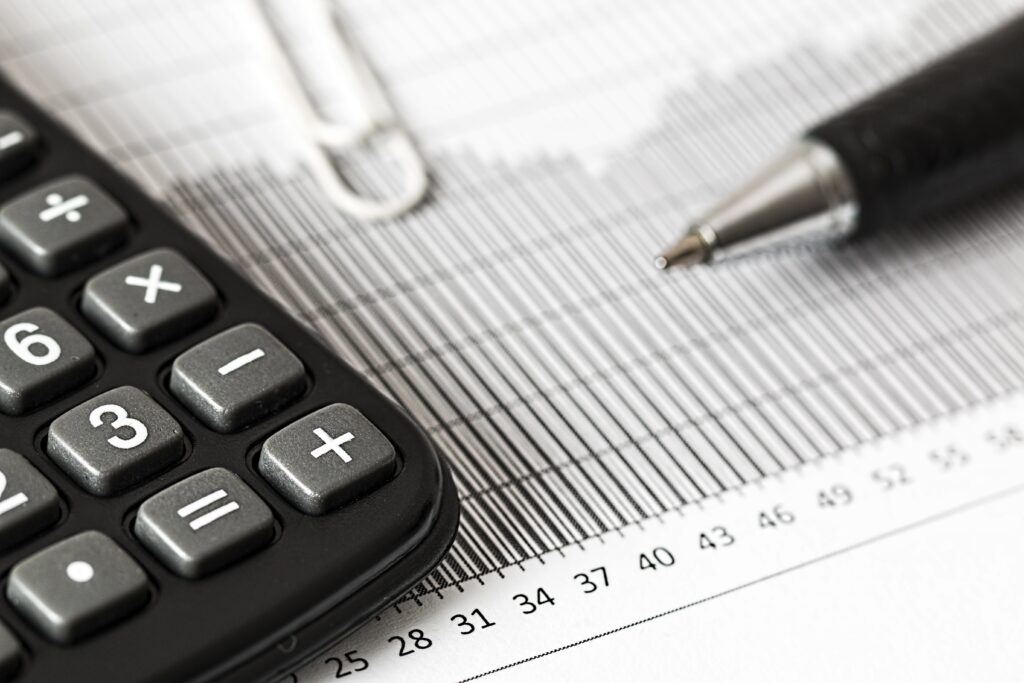 photo of calculator and pen signifying tax on a sale of an inherited mobile home