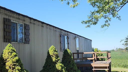 photo of a double wide mobile home that may be needing roof replacement