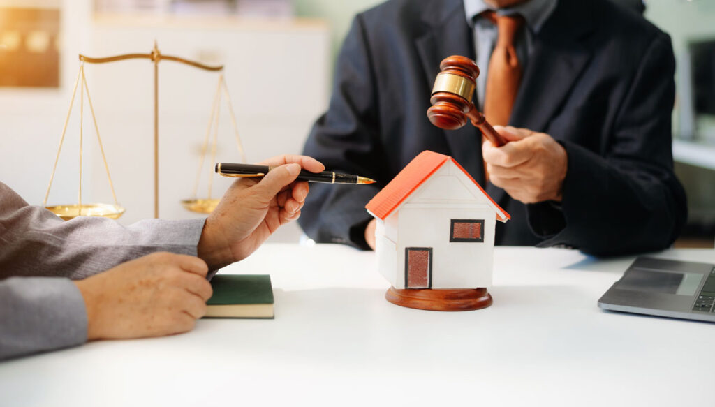 man holding gavel over model home