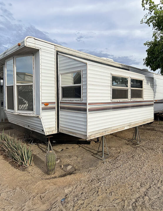 older white trailer on dirt